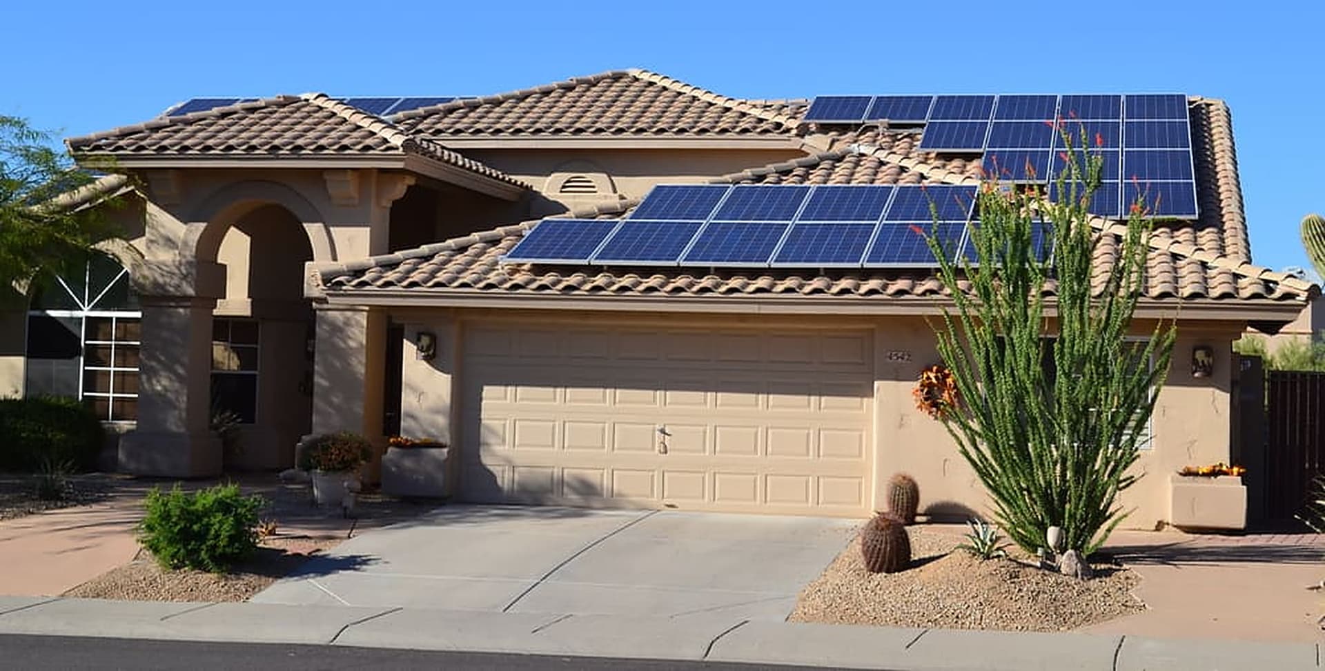 Rooftop solar array on a single-story stucco home with a tile roof