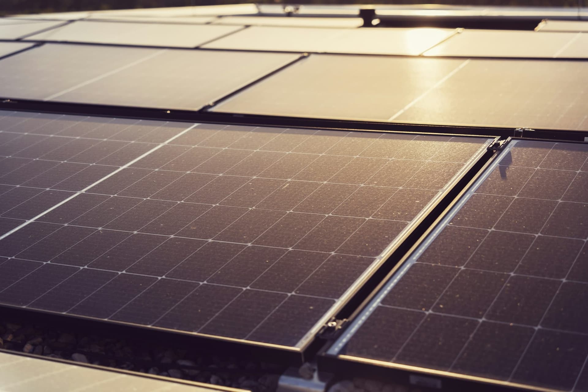 Solar panels on a rooftop catching low, hot evening light in the Antelope Valley